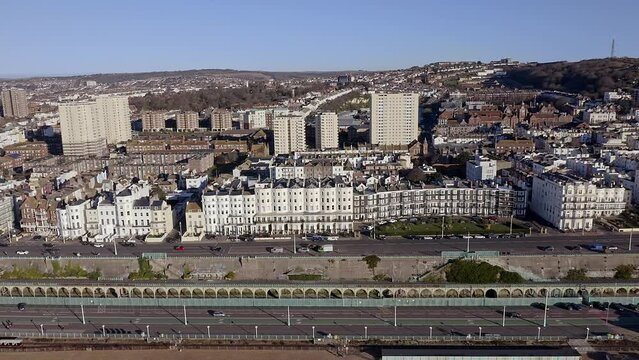 Brighton seafront with Victorian buildings along Marine Drive and Madeira Drive with the Volks Electric Railway in the foreground, Aerial video.