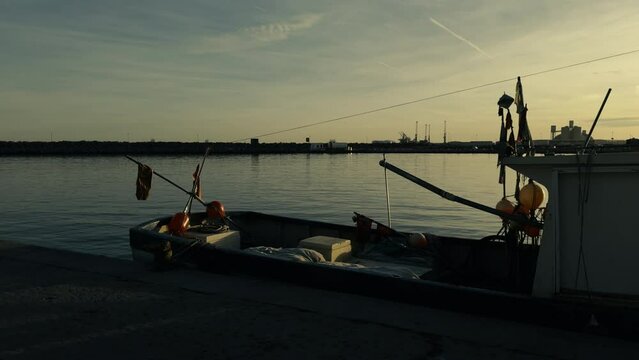Fishing boats and ships in the port of Castellon in winter. Port cranes on the horizon. Red floats for nets. Port of El Grao. Spain