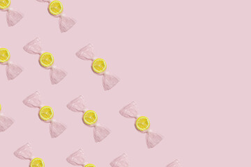 Pattern made of lemon wrapped like candy on bright pink background. Minimal food concept.