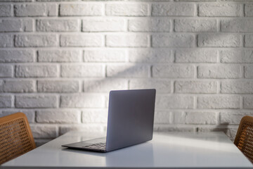 Laptop computer against white brick wall
