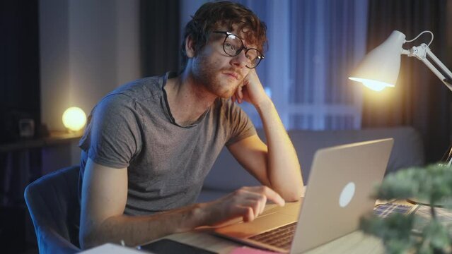 Boring tired student or freelancer typing on button during study or work at home workplace at late night Stressed male exhausted from remote distance work or education indoors