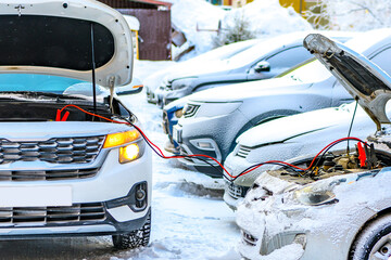 Charging automobile discharged battery by booster jumper cables at winter.  Problem starting a car...