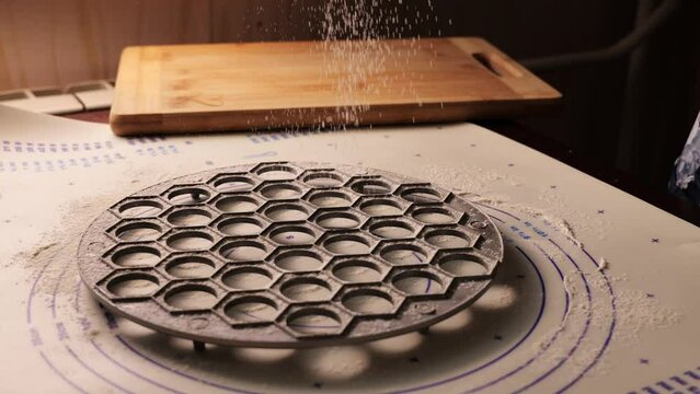 A girl pours flour into a metal bowl