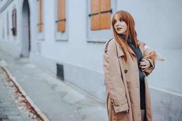 Obraz premium Fashion photo of a woman holding bouquet in a vintage street.