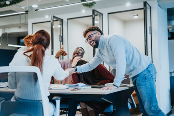 Multinational business partners laughing, enjoying and celebrating big success, victory or winning while working together at modern office.