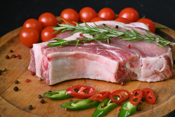 raw pork steak on the bone, rosemary sprigs, cherry tomatoes 