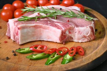 raw pork steak on the bone, rosemary sprigs, cherry tomatoes 