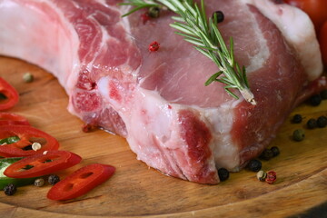 raw pork steak on the bone, rosemary sprigs, cherry tomatoes 