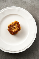 Single Golden Brown Chopped Chicken Cutlet or Patties with mozzarella cheese in white plate on concrete background. Top view
