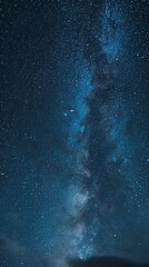 Night sky with dense stars and part of the Milky Way over a silhouette of mountains