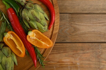 Overhead view of fresh and raw artichoke on the wooden table, vegetable composition bitter pepper, yellow pepper free place for text	

