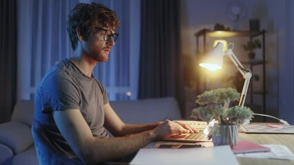 Tired young red hair student or freelancer feel stress during study or work at home workplace at late night Exhausted ginger male with remote distance work or education hard program indoors