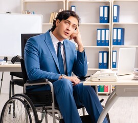 Male employee in wheelchair working at the office