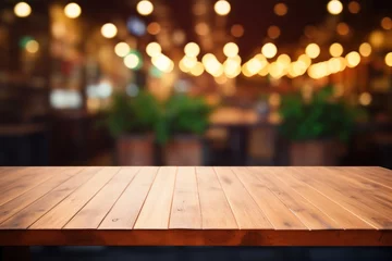 Foto op Plexiglas Wooden table against outdoor at street evening bar, featuring blurred defocused background with enchanting lights and copy space © Balica