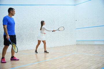 Man squash coach guides athlete woman has lesson on of skillful playing