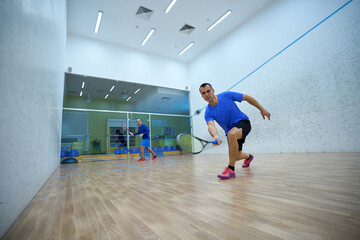 Athletic men challenging each other in squash enjoying the game
