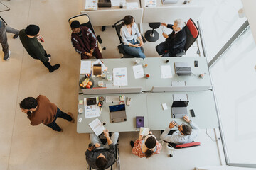Overhead view of a contemporary office space with a diverse group of professionals collaborating....