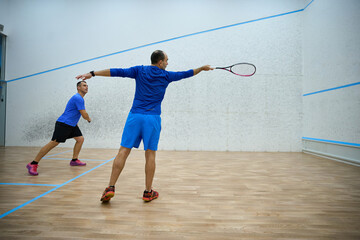 Energetic men training for squash enjoying active lifestyle