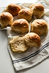 Burger Buns or mini buns on white marble background and kitchen towel. Very soft Freshly Baked Homemade, buttered. Minimalistic photo. 