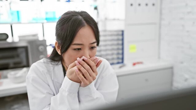 Shocked young chinese woman scientist covers mouth with hands in shock over a mistake at the lab, revealing chilling secret.