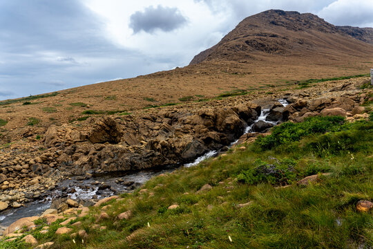 Tablelands in Gros Morne National Park, a Canadian national park and World Heritage Site in Newfoundland. An area where earth's mantle is exposed, peridotite rocks rich with iron rust, waterfall.