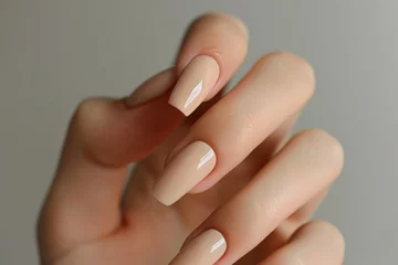 Wandcirkels tuinposter Closeup to woman hands with elegant neutral colors manicure. Beautiful nude manicure on long nails. Nude shade nail manicure with gel polish at luxury beauty salon © vejaa