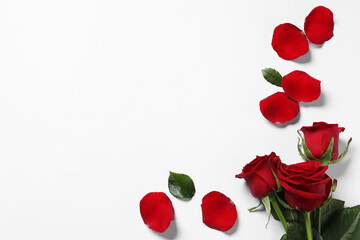 Fototapeta na wymiar Beautiful red roses and petals on white background, top view. Space for text