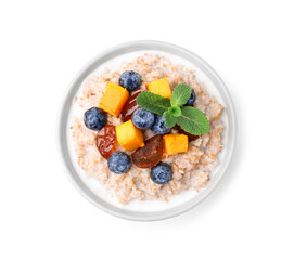 Tasty wheat porridge with milk, pumpkin, dates and blueberries in bowl isolated on white, top view