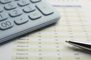 Calculator and pen on accounting document with data, closeup