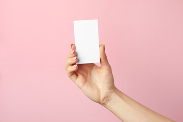 Woman holding blank business card on pink background, closeup. Mockup for design