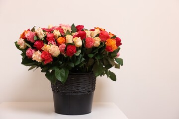 Bouquet of beautiful roses on table against light background. Space for text