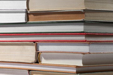 Stack of many different hardcover books as background, closeup