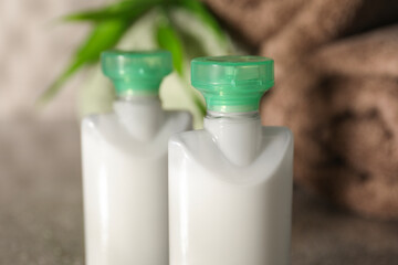 Mini bottles of cosmetic products on table, closeup