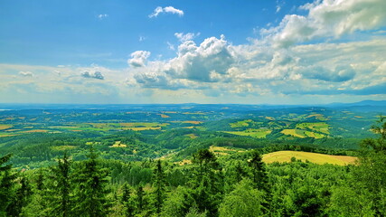Amazing - a beautiful view, from a bird's eye view, of a green forest, summer meadows, lush pastures and spring sown fields, a beautiful blue sky with white, soft, airy clouds
