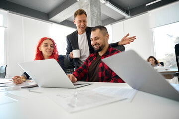 Cheerful businessman drinking coffee and talking to his colleagues