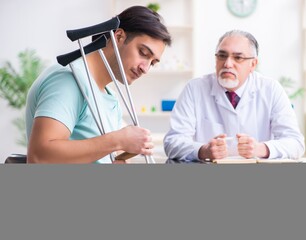 Young leg injured male patient visiting old doctor
