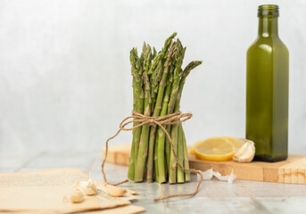 Bunch of Raw Asparagus with Garlic, Lemon, and Olive Oil with Stack of Recipes