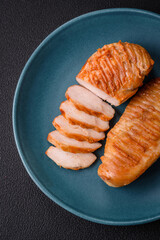Delicious fresh grilled chicken fillet with spices and herbs on a dark concrete background
