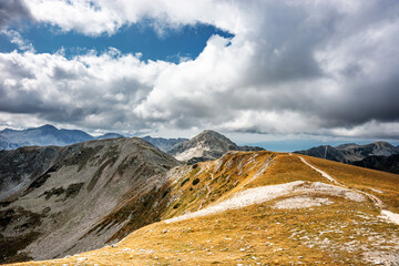 Fototapeta premium The pass between Vihren and Hvoinati peaks in autumn against Muratov peak. Autumn sunny day in Pirin highlands near Bansko, Bulgaria.