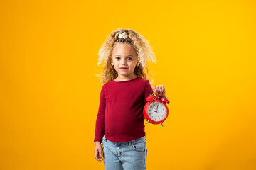 Young girl holding an alarm clock, symbolizing time management, education, school, and the urgency of deadlines and study.