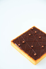 French dessert. Chocolate tart with chocolate ganache. White background. Back view.