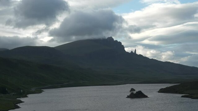 TIMELAPSE: Clouds roll around iconic Scottish mountains rising above Loch Fada. Dramatic landscape with mysterious peaks and wavy sea water on Isle of Skye. Atmospheric mood in remote countryside.