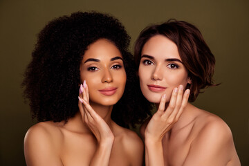 Portrait of two young stunning ladies touch cheek pure aesthetic applying lotion isolated on khaki color background - obrazy, fototapety, plakaty