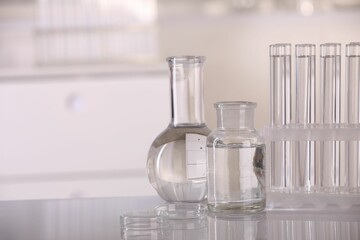 Laboratory analysis. Different glassware with liquid on white table indoors, space for text