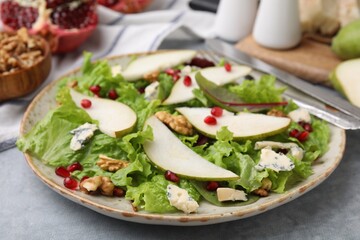 Delicious pear salad on grey textured table, closeup