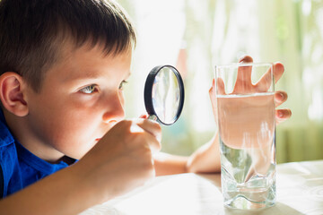 Boy Investigating Water with Magnifying Glass © spyrakot