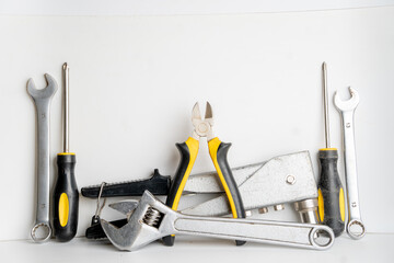 construction tool kit on white background, pliers, screwdriver, wrench, riveter, adjustable wrench,...