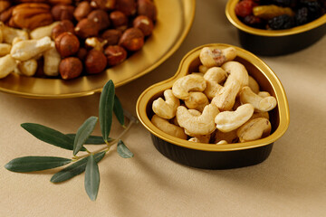 Mixed nuts and dried fruits on a gold plates. Symbols of the Jewish holiday of Tu Bishvat. Healthy snack - mix of organic nuts and dry fruits.