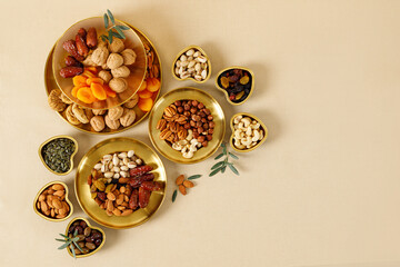 Mixed nuts and dried fruits on a gold plates. Symbols of the Jewish holiday of Tu Bishvat. Healthy snack - mix of organic nuts and dry fruits.
