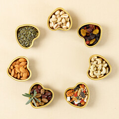 Mix of dry fruits and nutsinon on golden heart shaped plates with olive leaves. Concept of the Jewish holiday